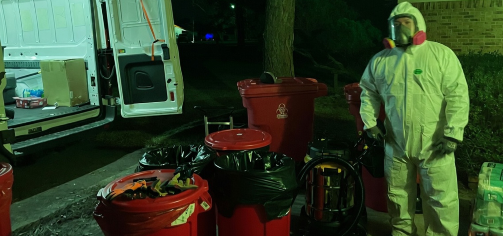 Hazardous waste cleanup crew handling red biohazard containers